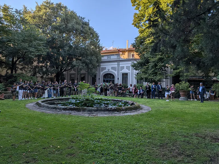 people gathered in gardens with fountain