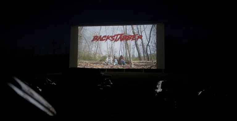 dark enviornment with a screen with the word backstabber on it