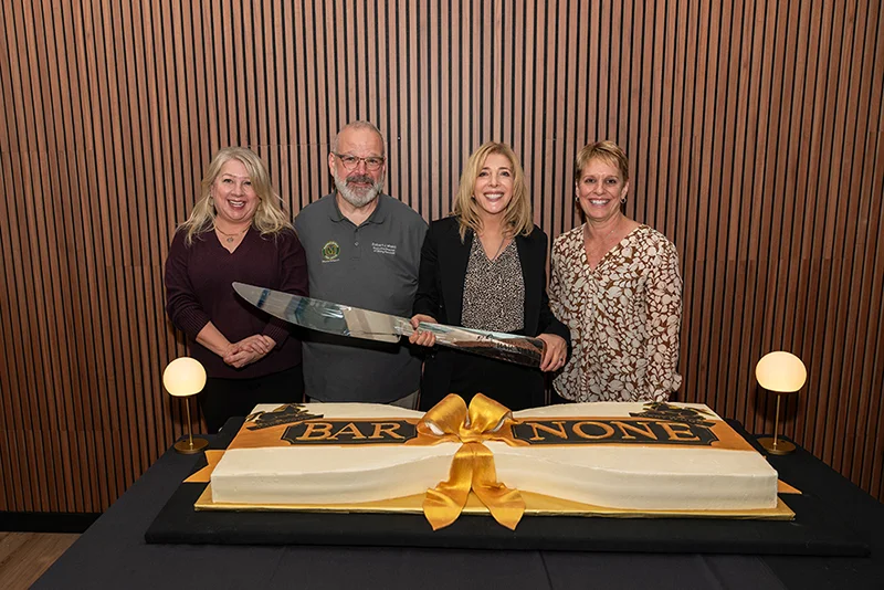 photo of four individuals with a large knife in front of a cake Marywood University Celebrates Grand Opening of Bar None, highlighting vision for vibrant Campus Life