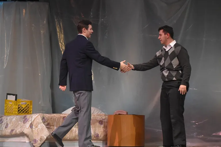 two men about to shake hands on a stage