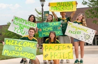 Students holding colorful green and yellow signs with Pacer Pride and Welcome to Marywood on them.