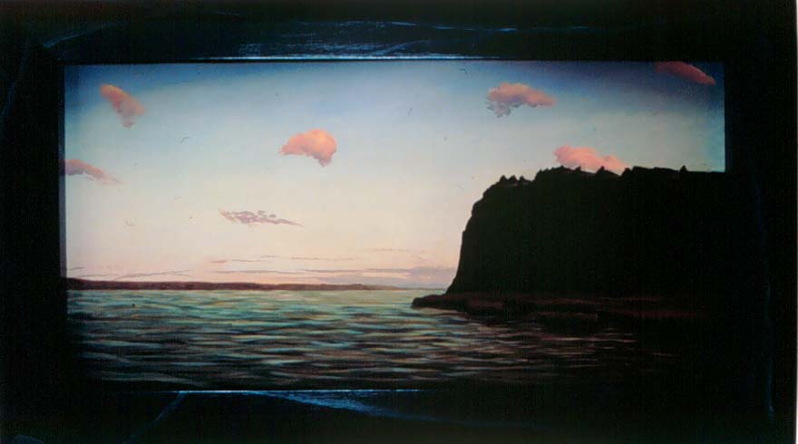 darkened photo of water with a cliff to the right